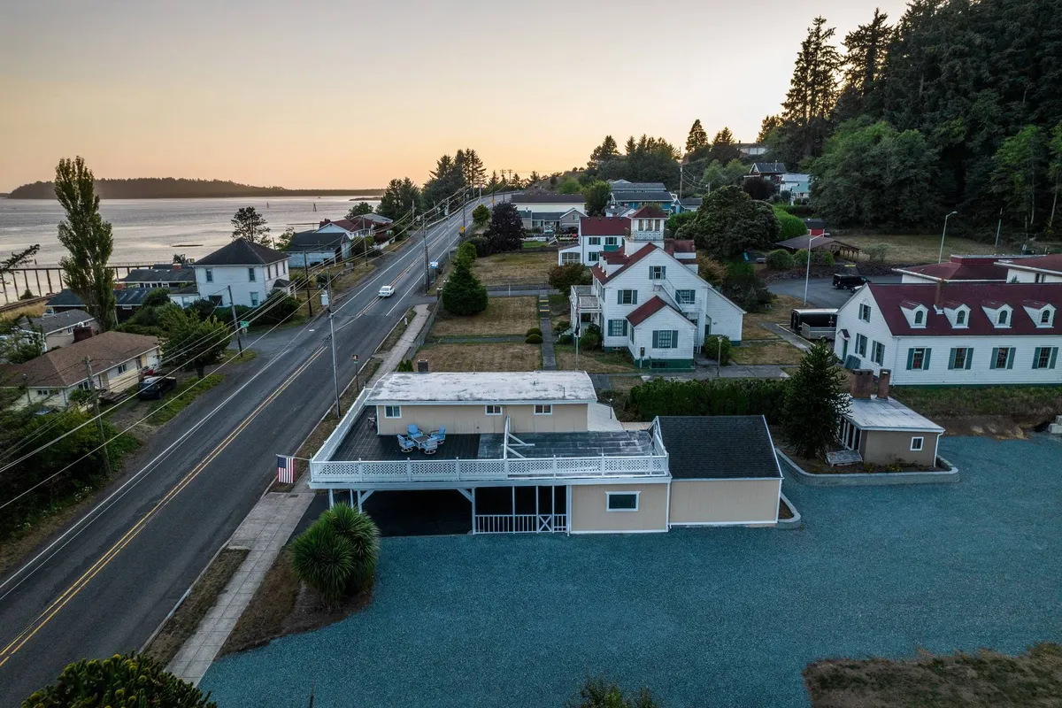 A tranquil street scene featuring houses with diverse architecture, a road leading toward the waterfront, and green trees lining the street. The image captures the essence of walkability and proximity to both town and the marina, echoing the section's emphasis on exploration and local access.